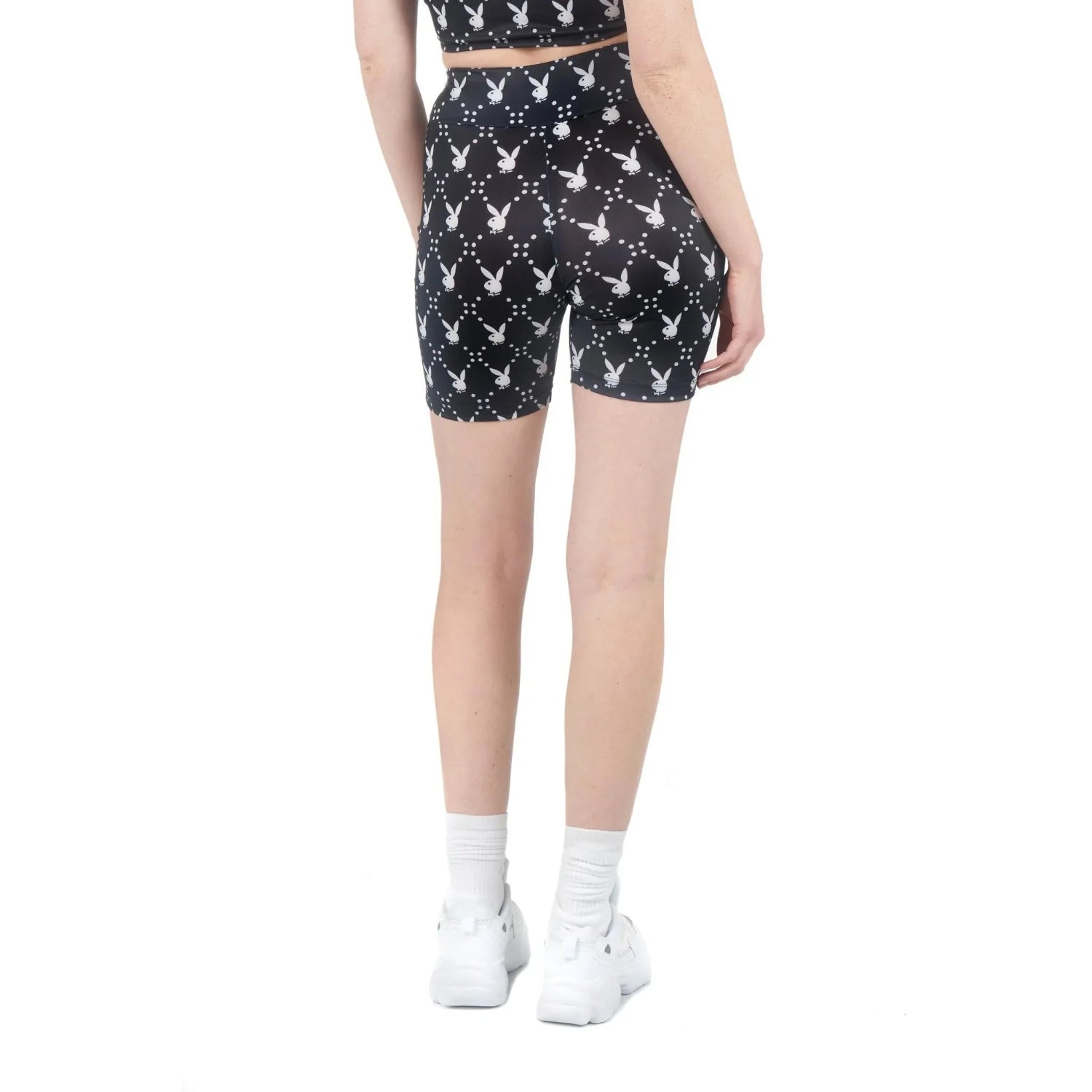 Woman wearing black high-waist bike shorts with white rabbit head pattern, rear view