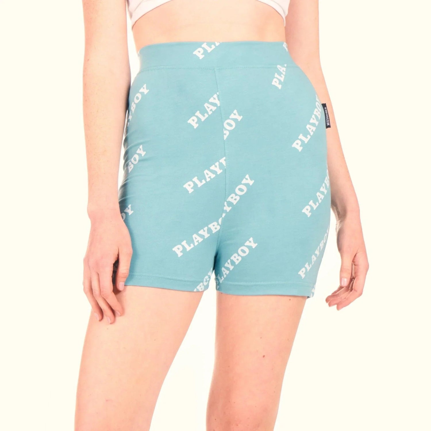 Aqua blue women's bike shorts with repeating white logo print, shown on model
