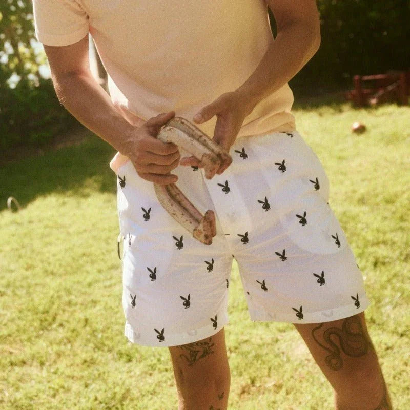 White lounge shorts with repeating black rabbit head print worn outdoors