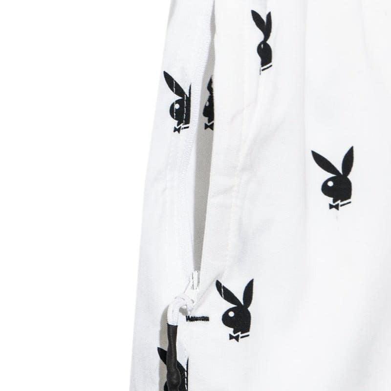 White lounge shorts with repeating black rabbit head pattern and zipper pocket detail