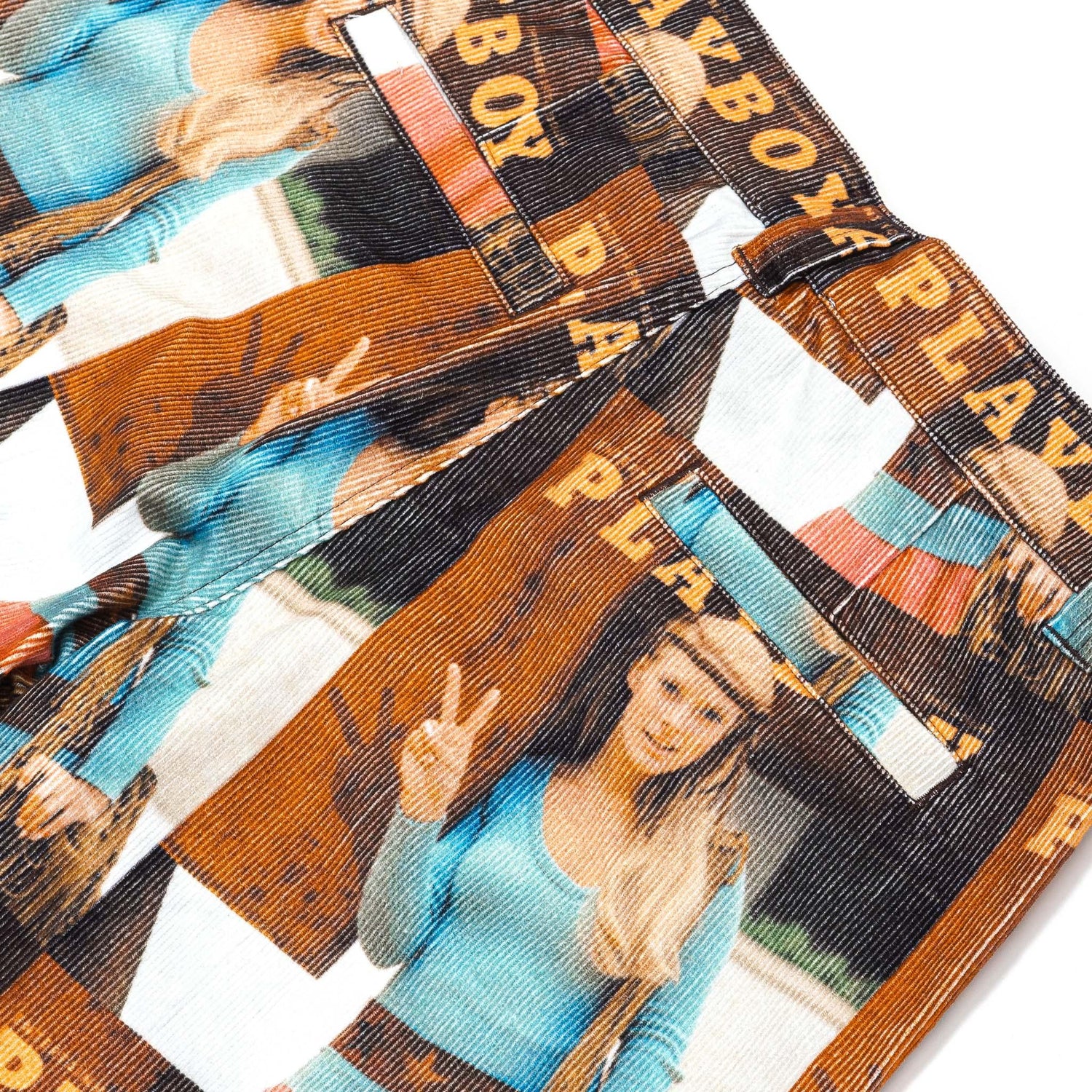 Close-up of pants with vintage magazine cover print, featuring woman in blue top and peace sign.