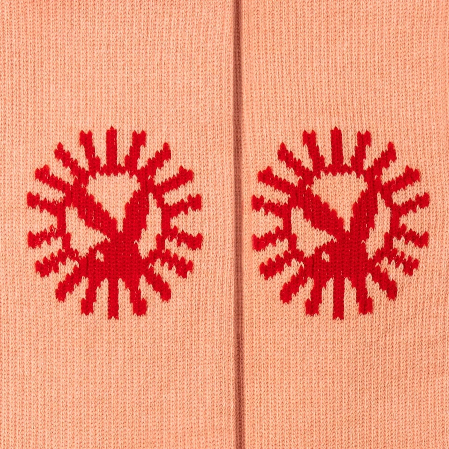 Peach crew socks with bold red sun pattern knit design, close-up detail view