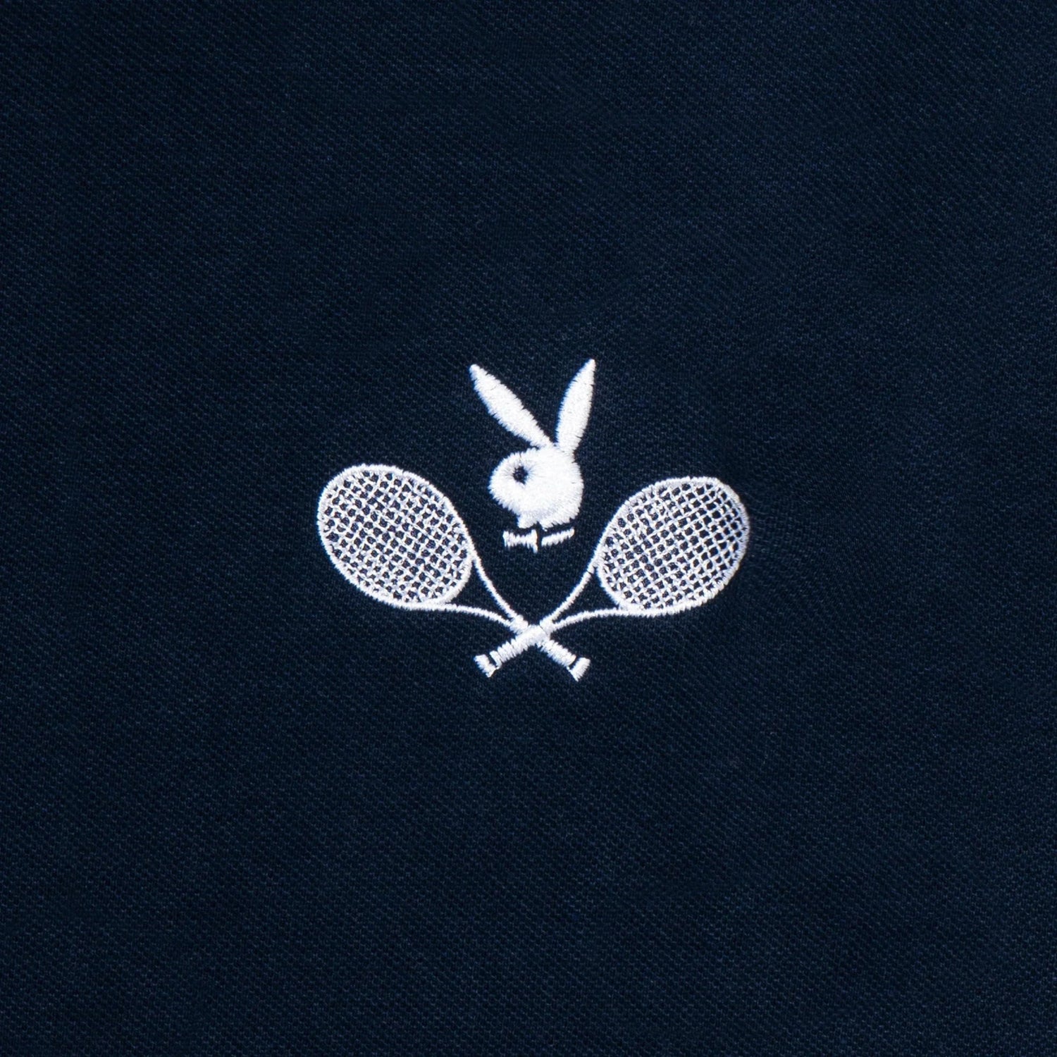 Navy polo shirt with white embroidered tennis rackets and bunny logo design
