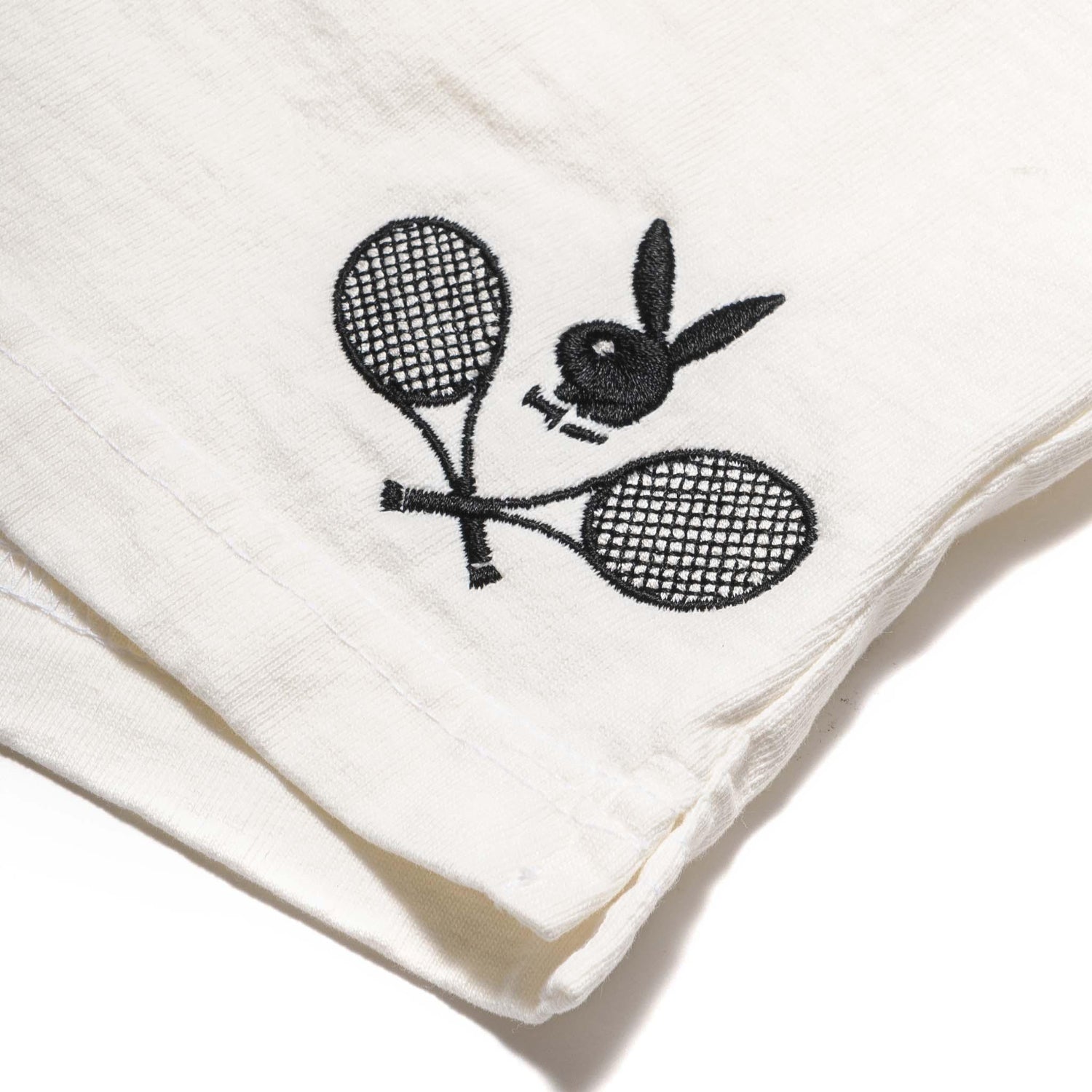 White shorts with black embroidered tennis racquets and bunny logo detail