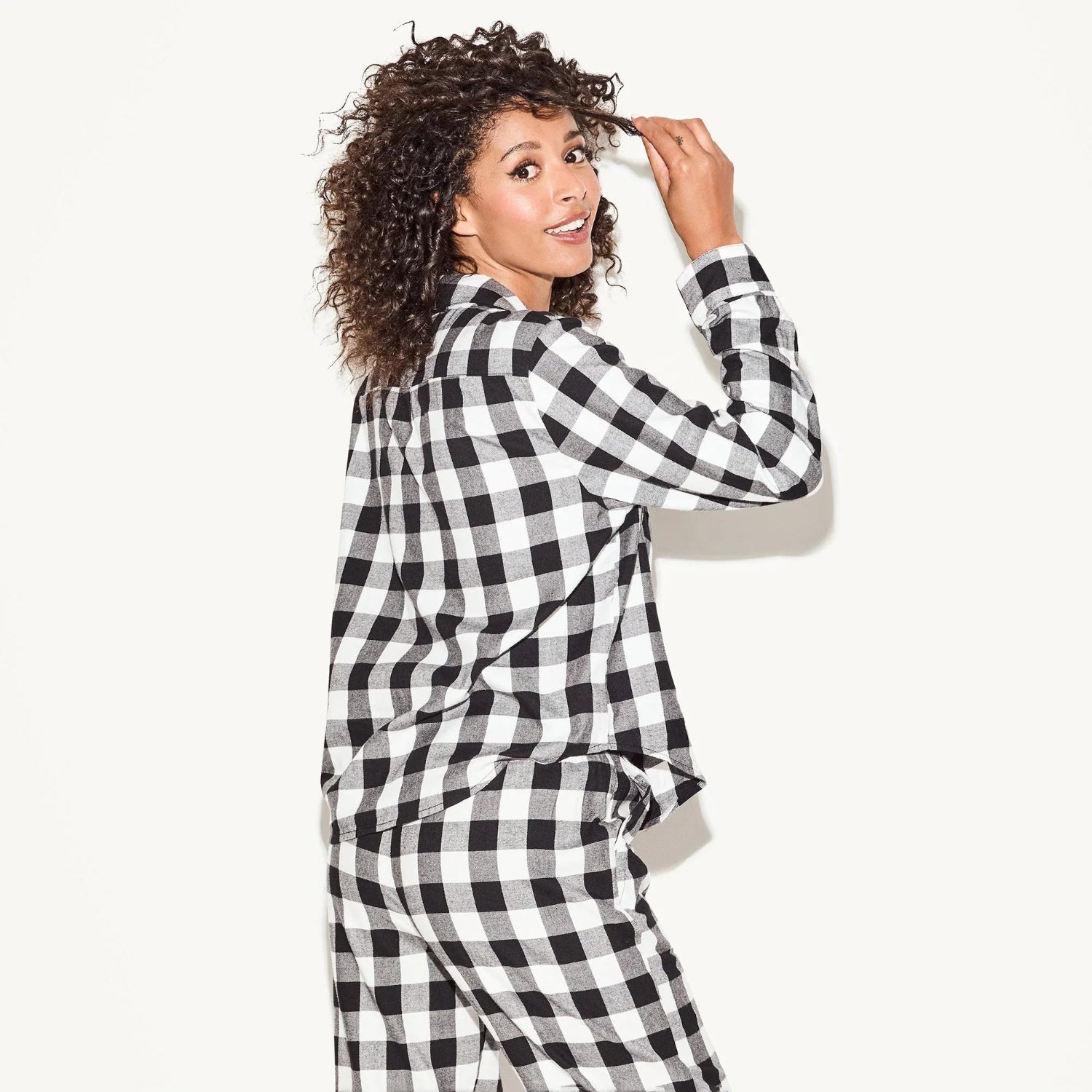 Woman in black and white checkered flannel sleep shirt and pants set