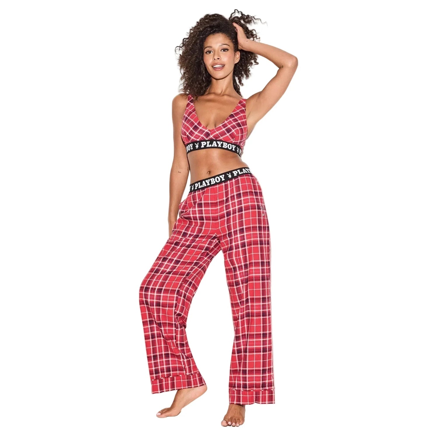 Woman wearing red plaid flannel pajama pants and matching bralette with bold waistband.