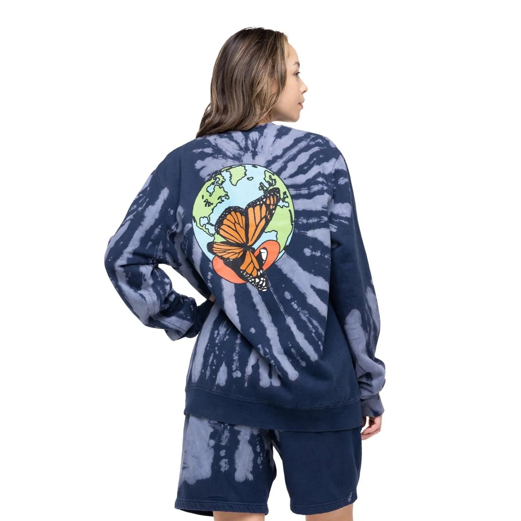 Woman wearing navy tie-dye sweatshirt with butterfly and earth graphic on the back
