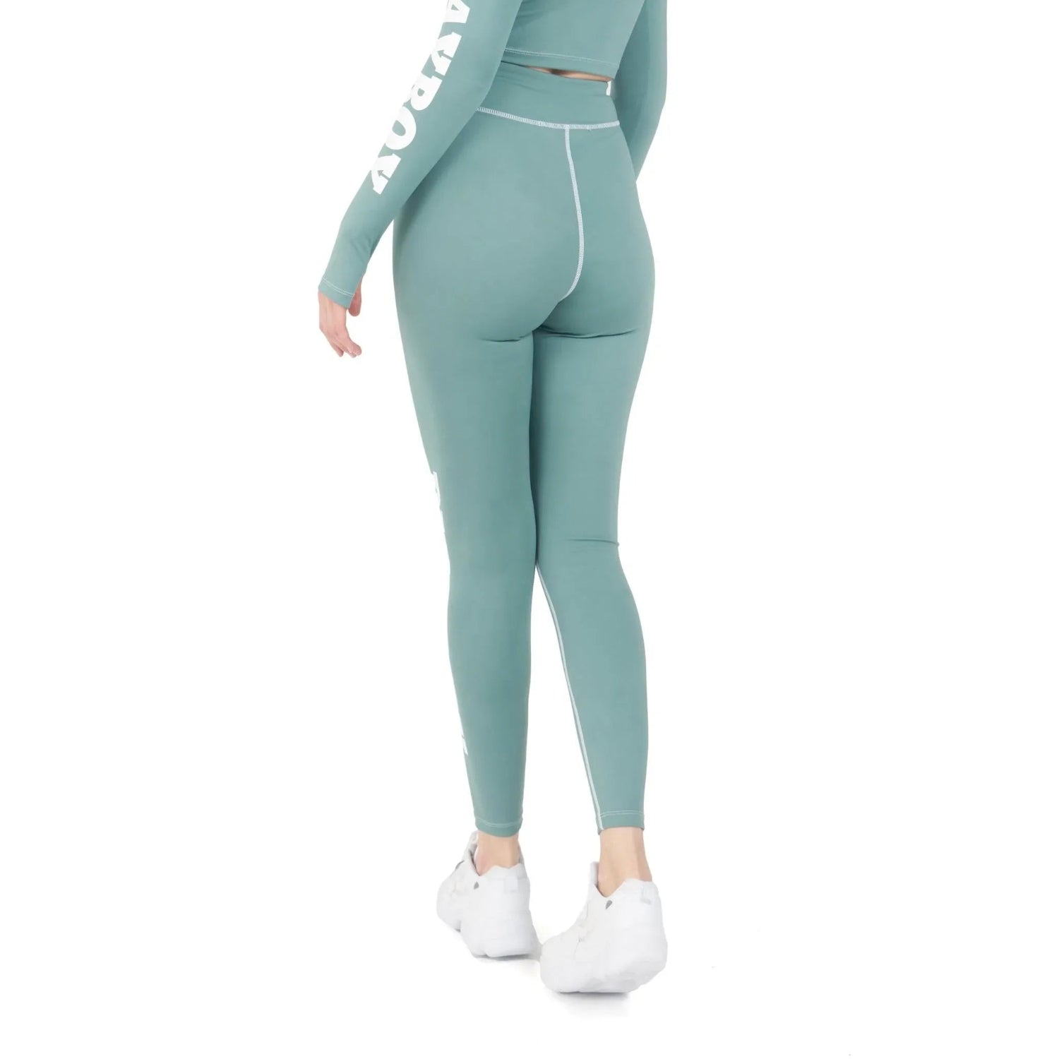 Woman wearing high-waisted teal active leggings with white stitching, back view