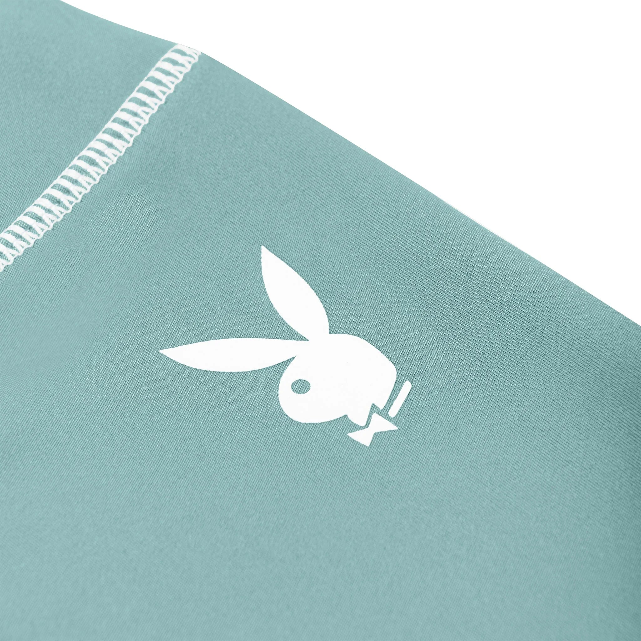 Close-up of teal women's active leggings with white rabbit head logo and visible stitching.
