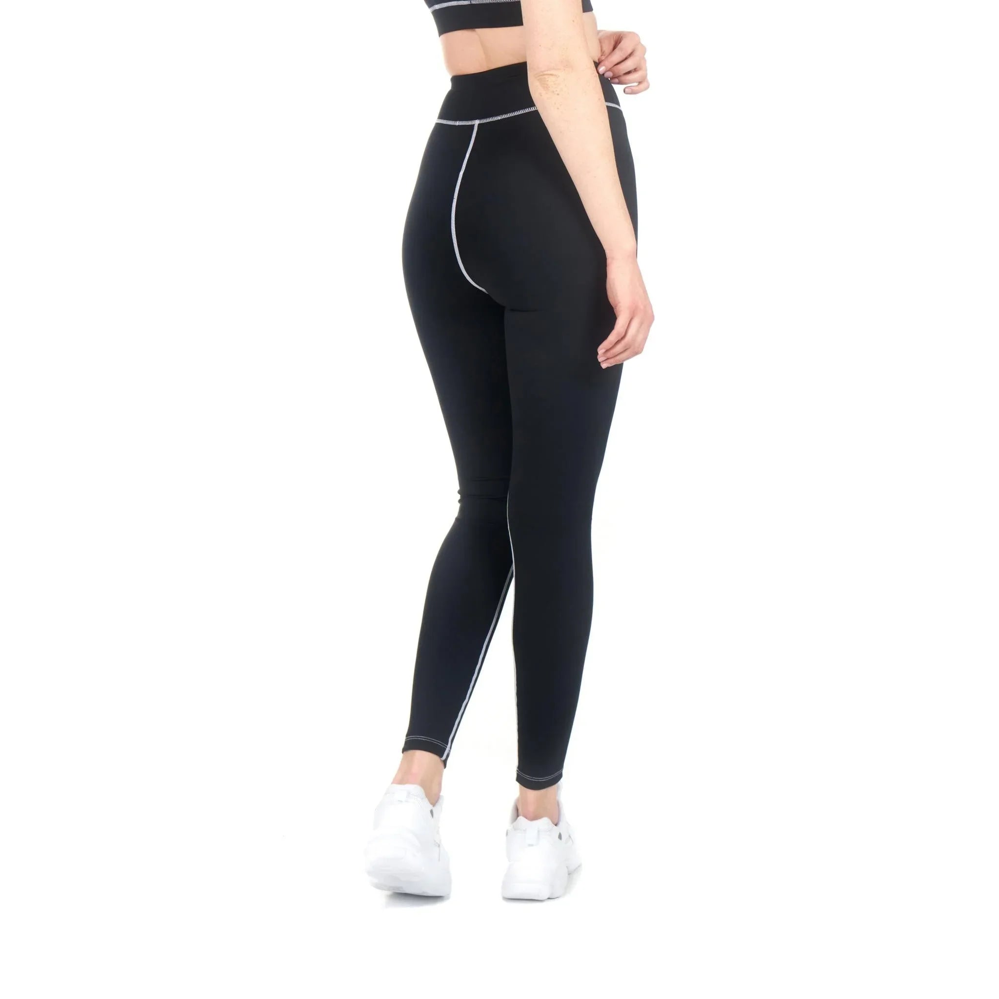 Woman wearing black active leggings with contrast stitching, shown from the back.