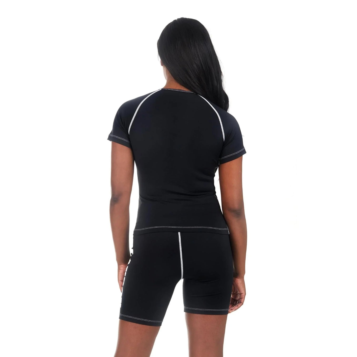 Woman wearing black active short sleeve tee and matching shorts with contrast stitching, back view