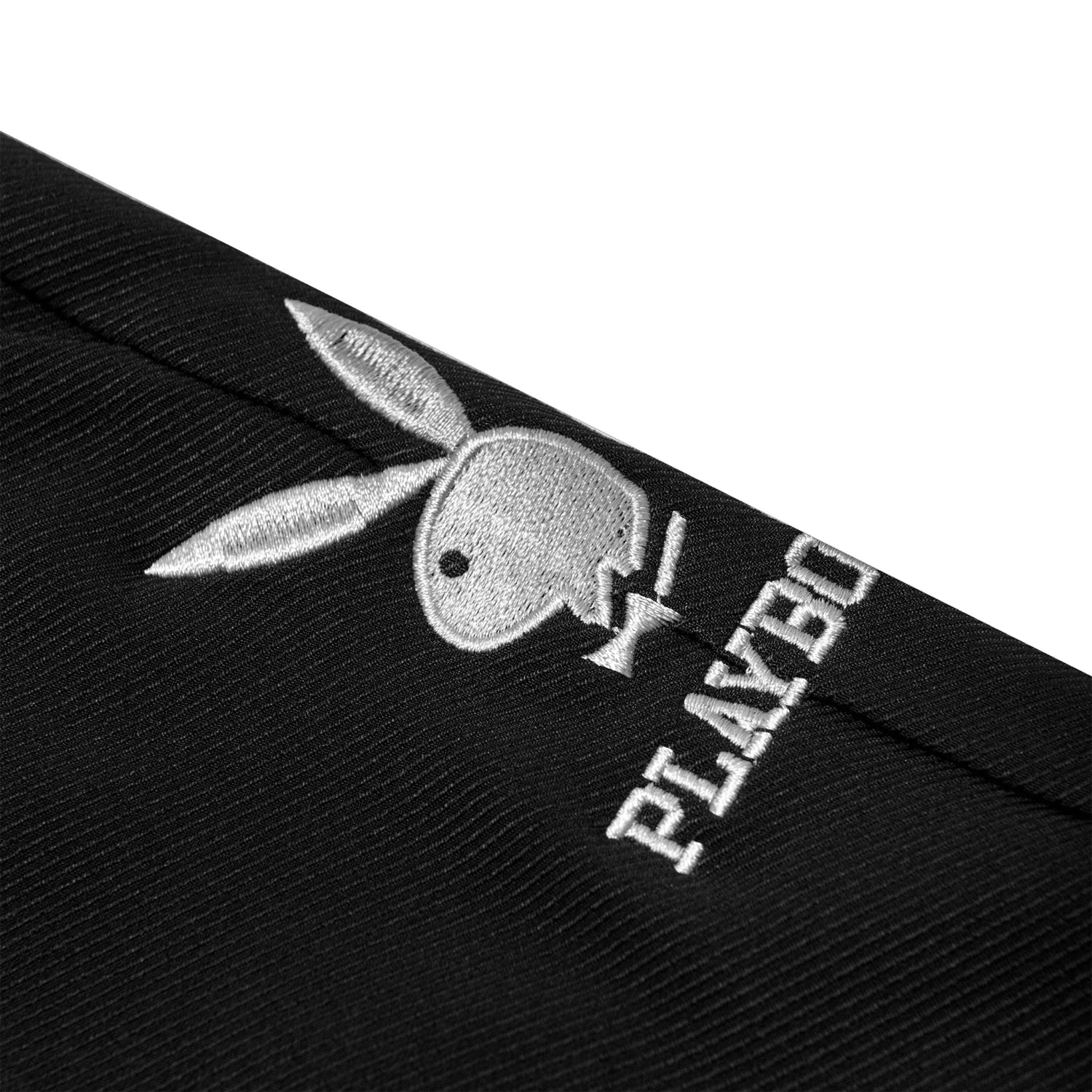 Close-up of black women's trouser with embroidered white bunny logo and text detail