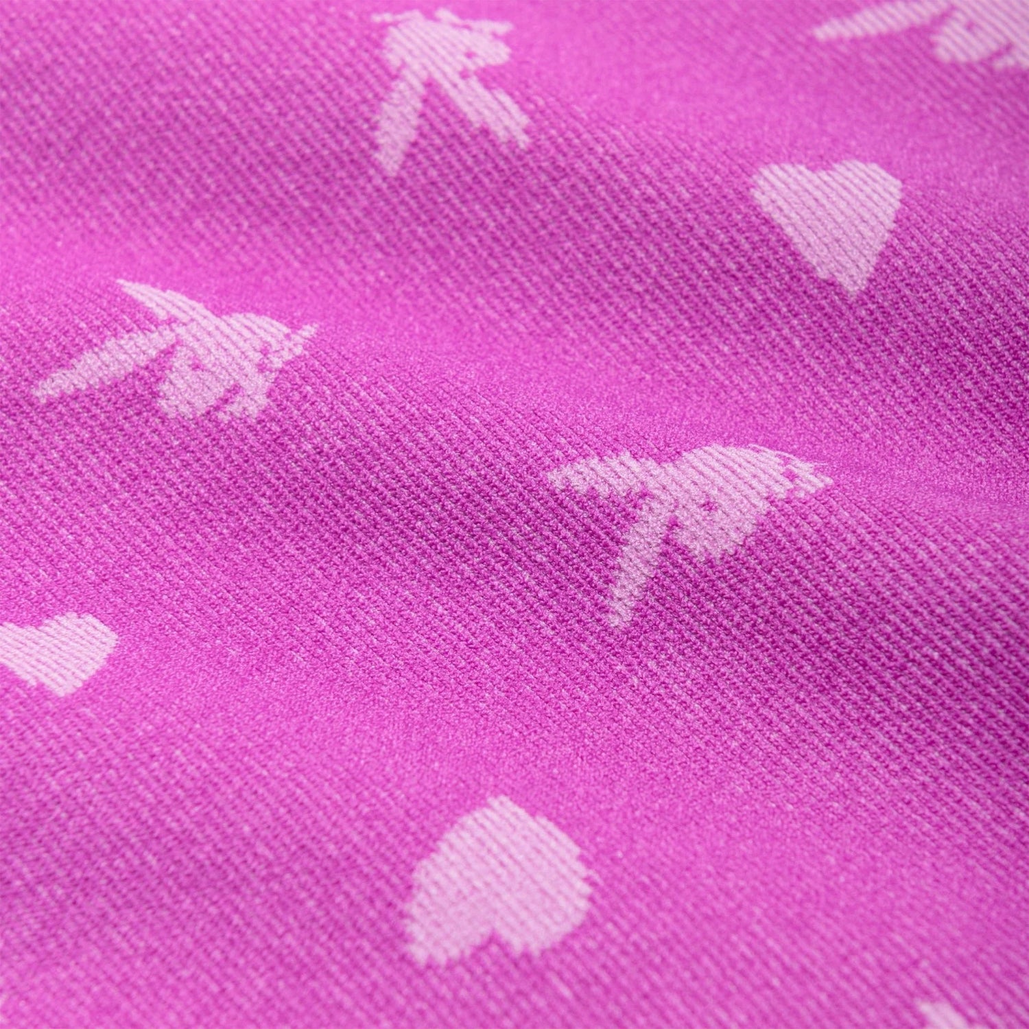 Close-up of pink seamless cami fabric with white bunny and heart pattern, women's clothing detail