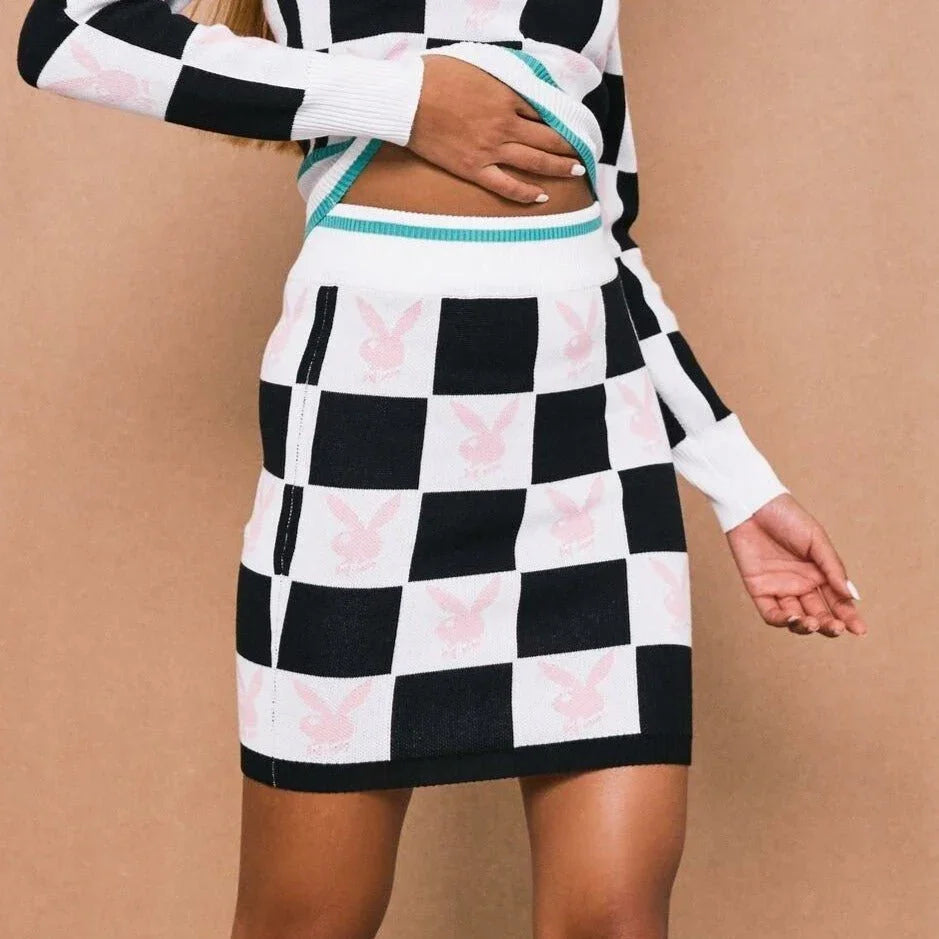 Woman wearing black and white checkerboard mini skirt with pink bunny logo pattern