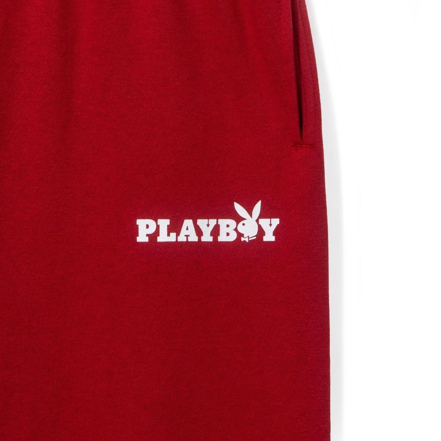 Red women's boyfriend sweatpants with white Playboy logo and bunny graphic on pocket