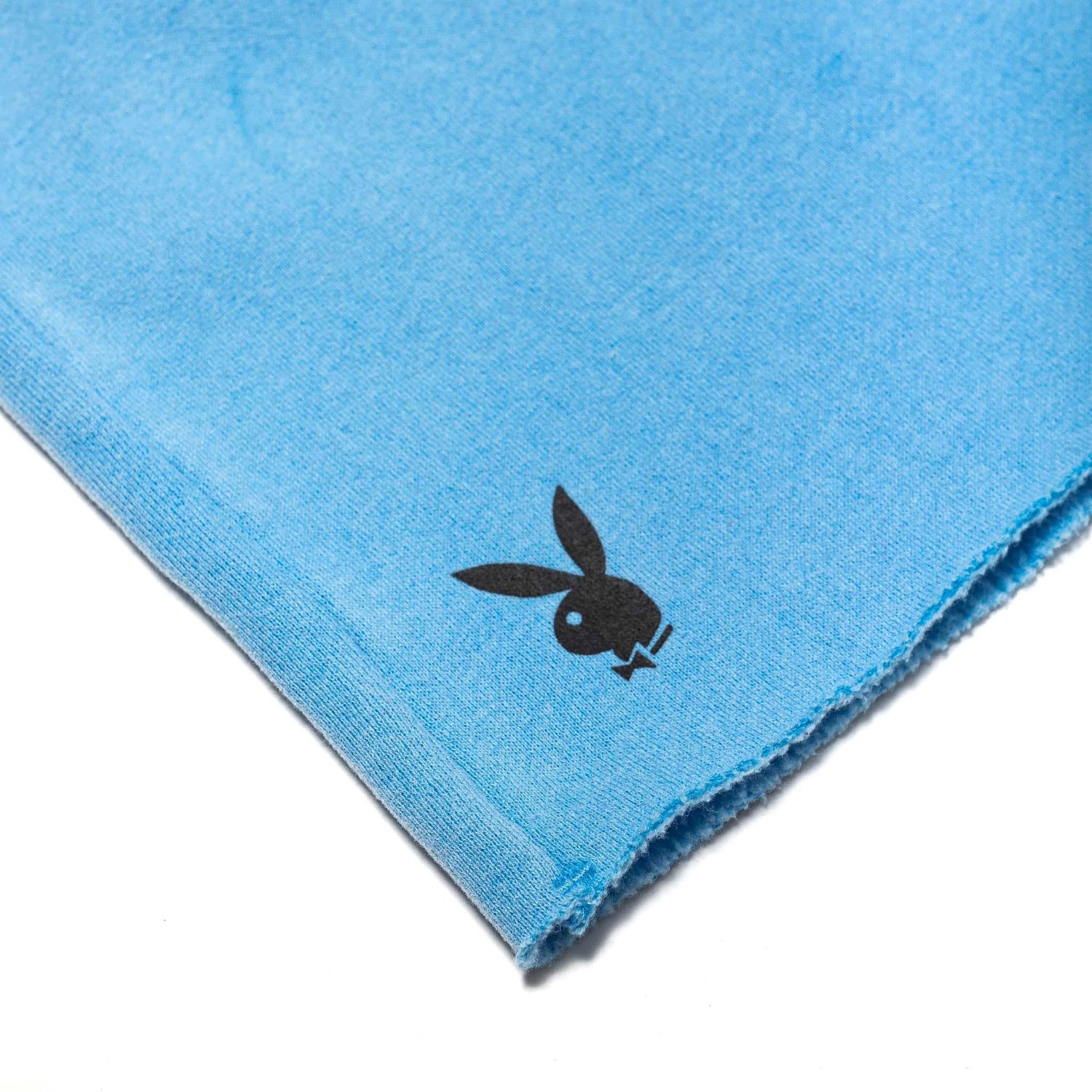 Close-up of blue women's shorts with raw hem and black bunny logo print
