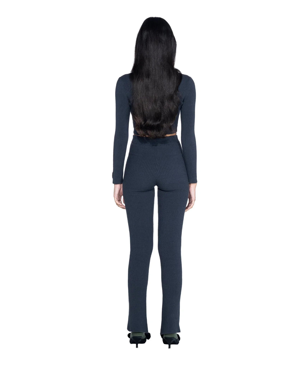 Woman wearing black ribbed cropped long sleeve top and matching pants, back view