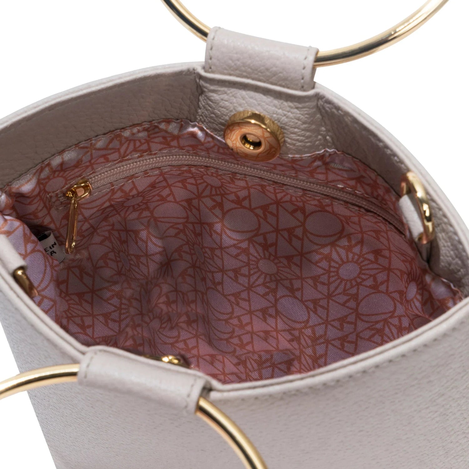 Closeup of women's leather ring clutch interior with gold hardware and patterned lining