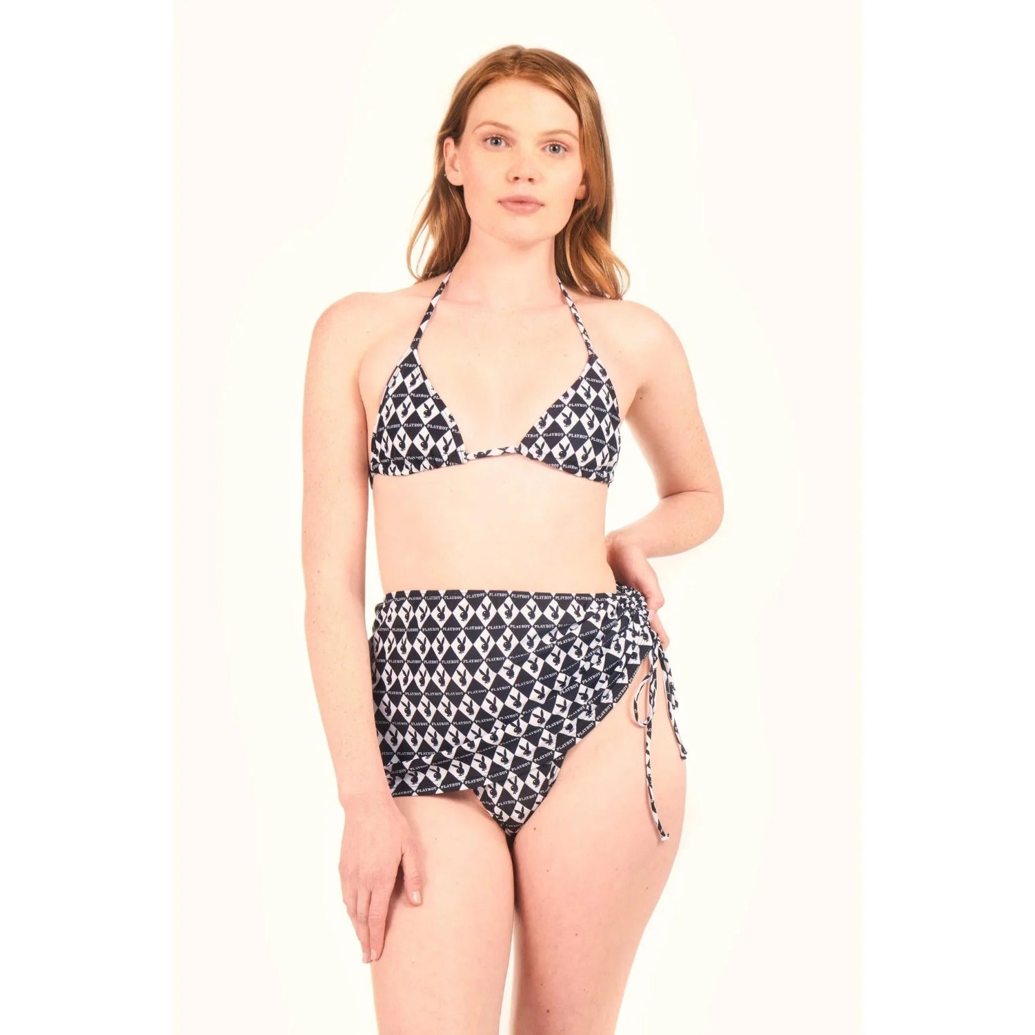 Woman wearing black and white monogram bikini top and mini sarong skirt, front view