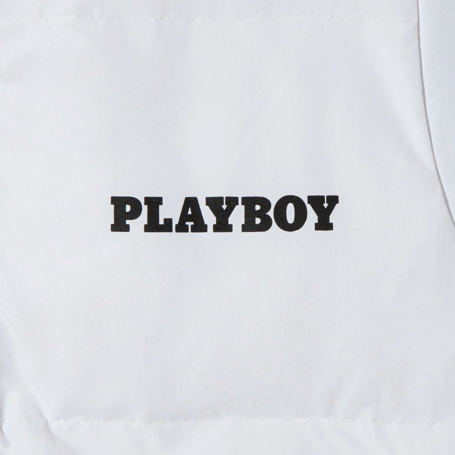 White women's puffer vest with bold black PLAYBOY text on the front.