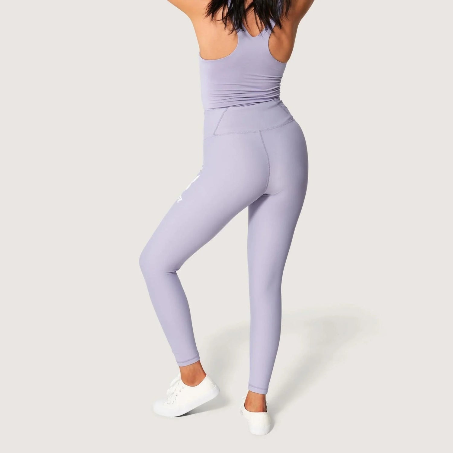 Woman wearing light purple high-waisted leggings with white rabbit head graphic