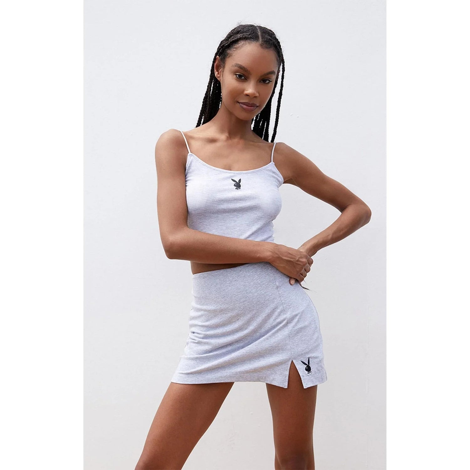 Woman modeling light grey slit mini skirt and crop top set with bunny logo details