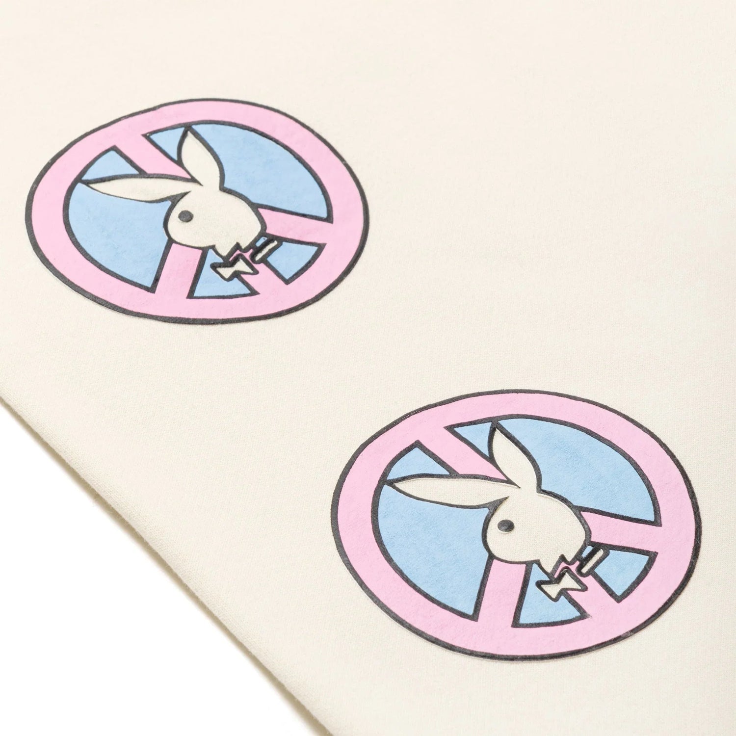 Close-up of cream sweatpants with pink and blue bunny face graphic print details
