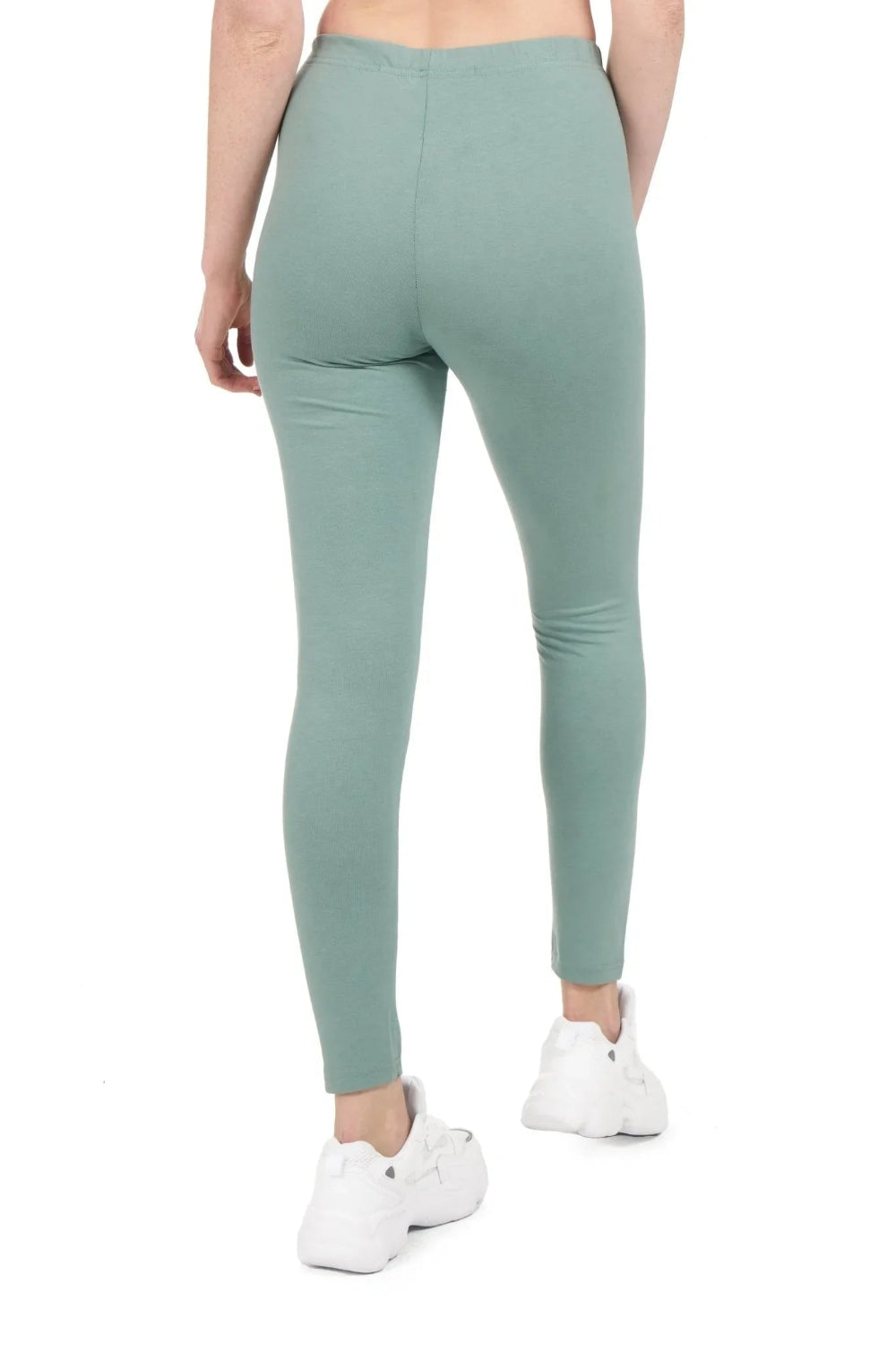 Back view of woman wearing light green full-length leggings and white sneakers