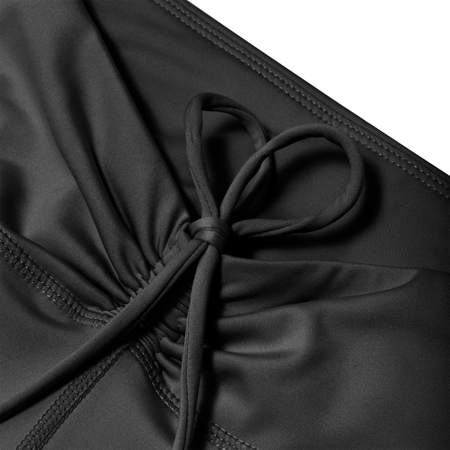 Close-up of black ruched waistband leggings with drawstring and visible stitching.