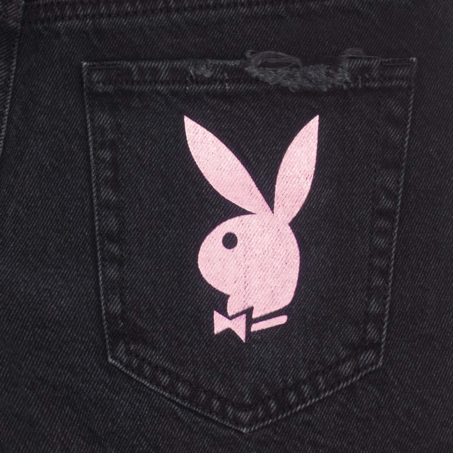 Close-up of black denim shorts pocket with a pink bunny graphic print