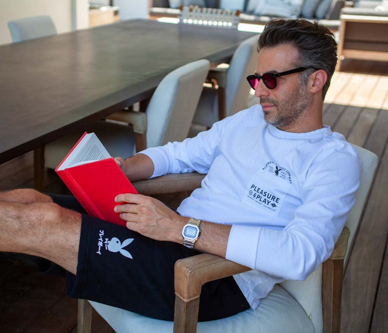 Man reading a book wearing Playboy shirt