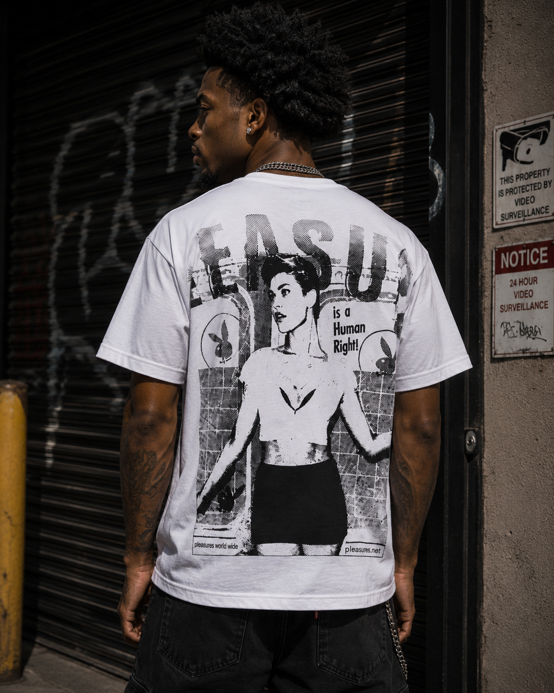 A man viewed from behind wearing a white graphic t-shirt with a large black-and-white print of a woman and the text 'FASD' and 'is a Human Right'. #Streetwearmen
