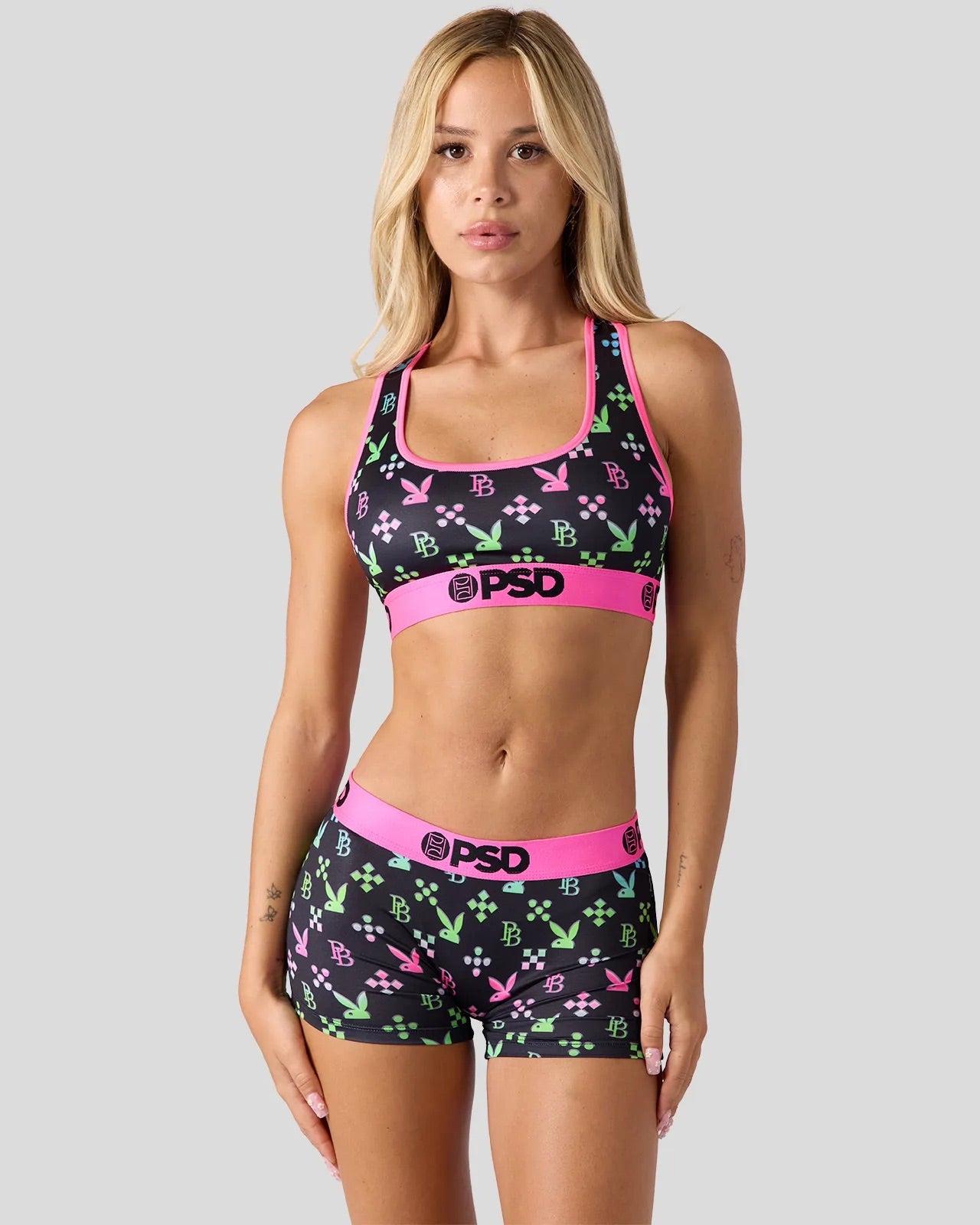 Woman wearing a sports bra and shorts set with 'PSD' branding on a gray background