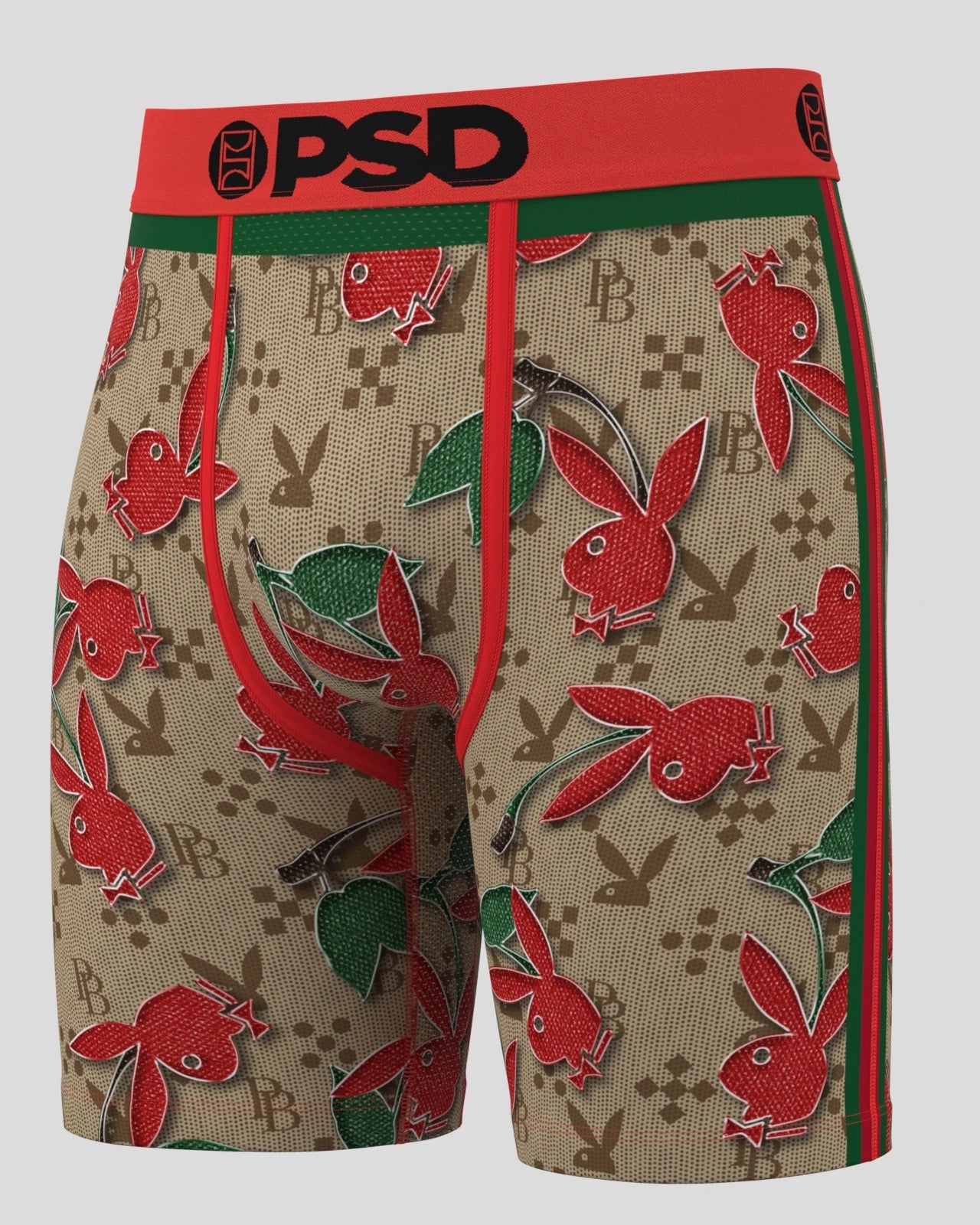 A pair of boxer briefs featuring a beige monogram pattern with red Playboy bunny and fish motifs, a red waistband with 'PSD' in black, and green and red side stripes, shown against a light gray background.