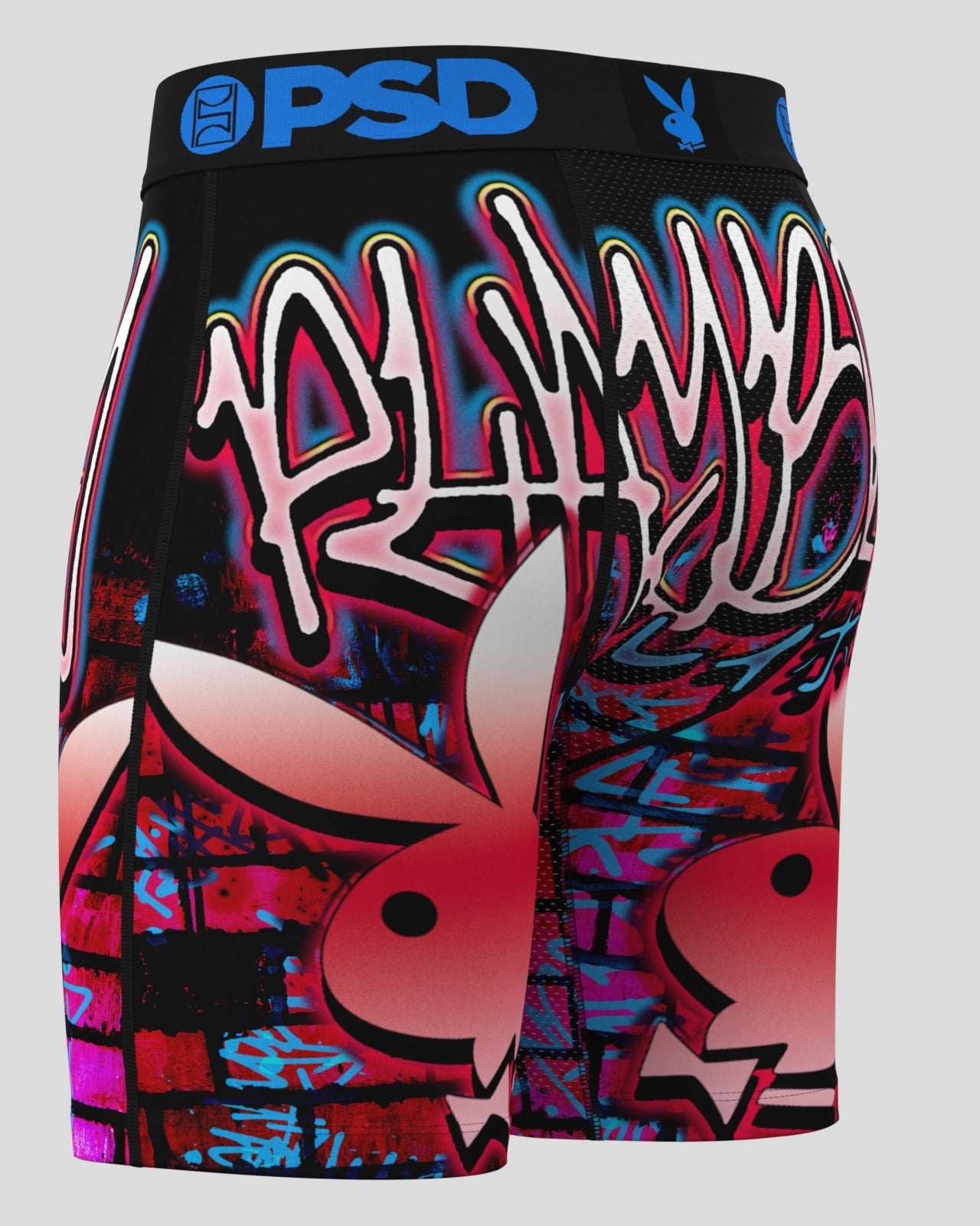 Black athletic shorts featuring a vibrant graffiti-style graphic print in pink, red, blue, and white, with the Playboy bunny logo and 'PSD' branding on the waistband.