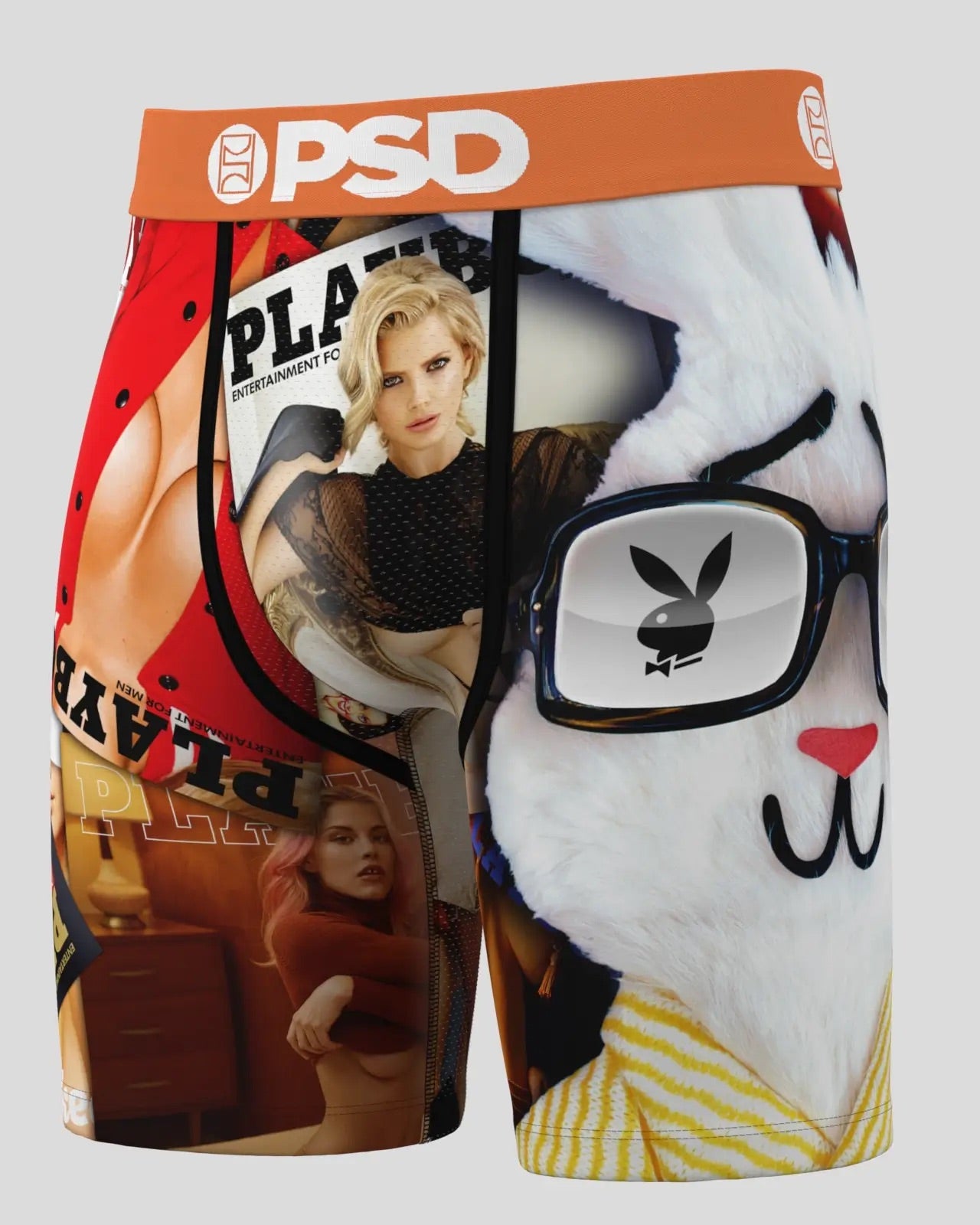 A pair of boxer briefs featuring a complex graphic collage print with a large white bunny face wearing glasses, a red and black Playboy magazine cover, and a model photo. The waistband is orange with white 'PSD' branding.