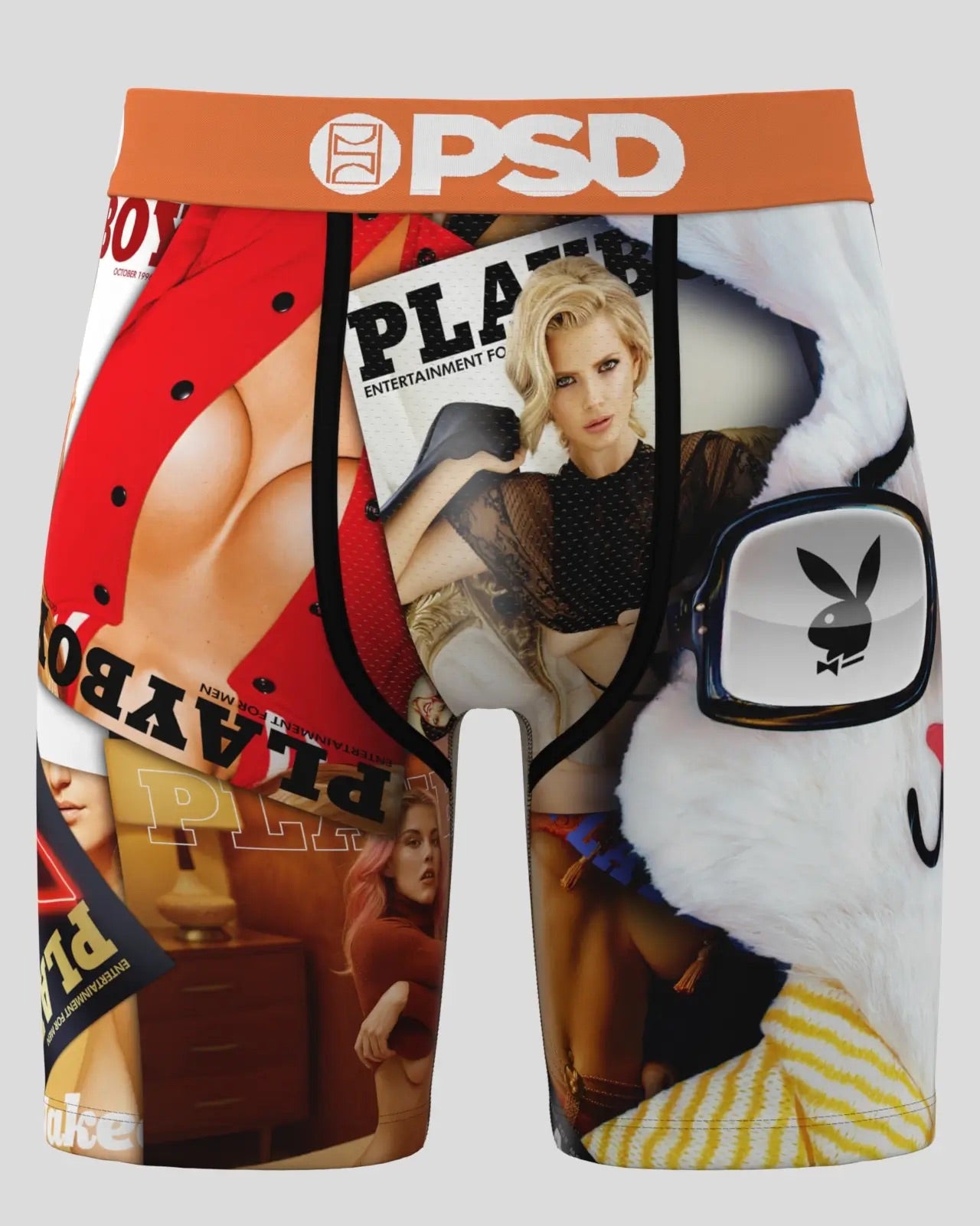 A pair of boxer briefs featuring a collage print of Playboy-themed imagery, including a red bikini, a magazine cover with a woman, a white bunny head graphic, and a yellow-and-white striped pattern. The waistband is orange with a white PSD logo.
