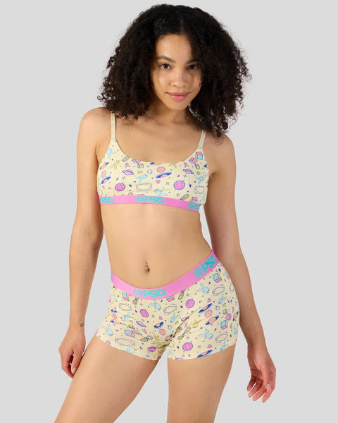 Woman wearing a colorful patterned bikini set on a plain background