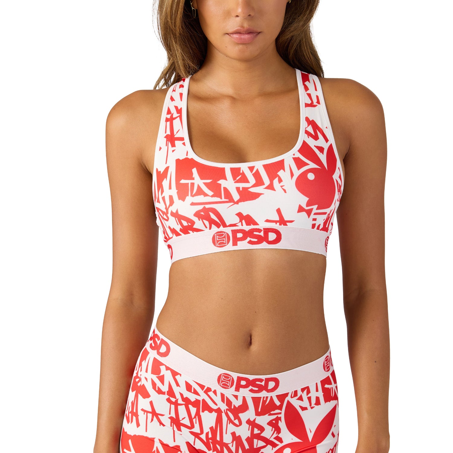 Woman wearing red and white sports bra and shorts with graphic print and bunny logo