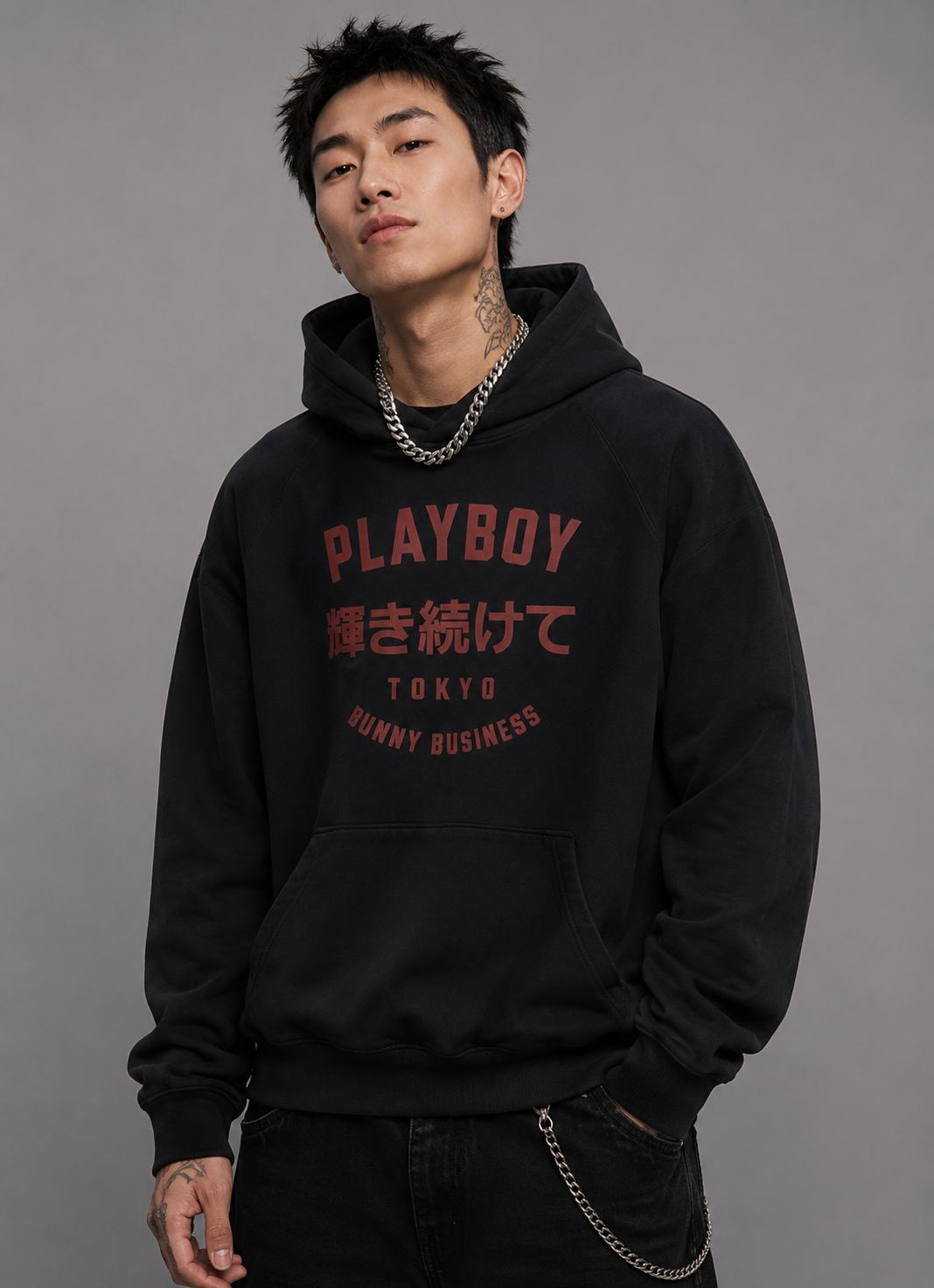 A man wearing a black hoodie with red and white text reading 'PLAYBOY' and 'BUNNY BUSINESS' on the front, posed against a solid gray studio background. #Streetwearmen