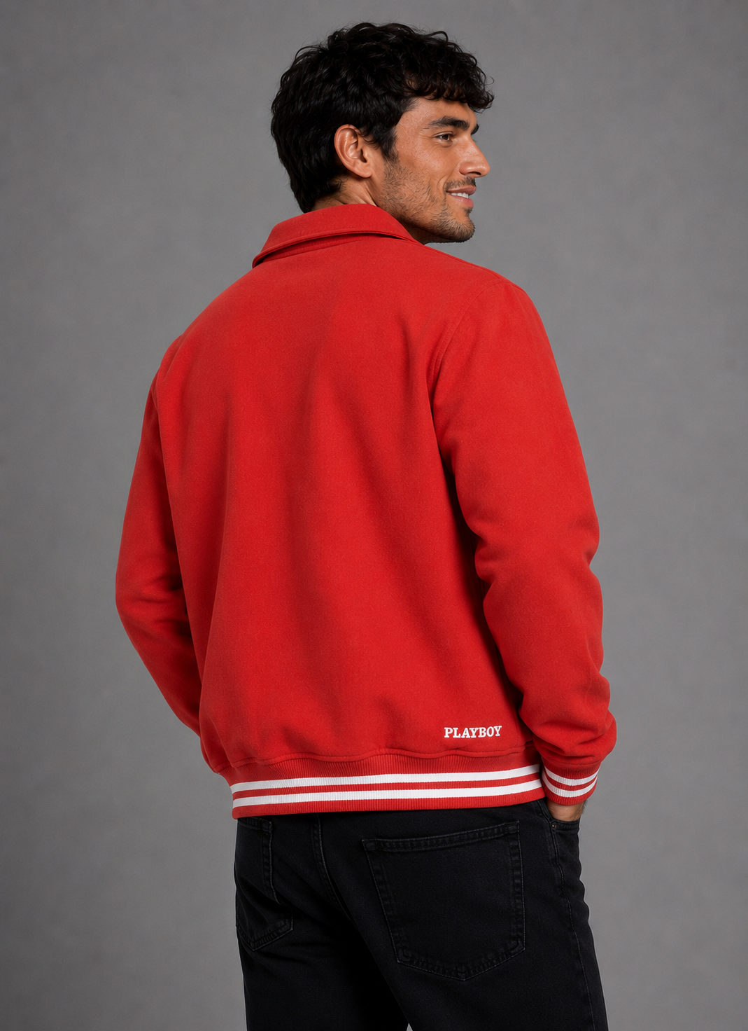 A man wearing a bright red fleece jacket with white stripes on the hem and cuffs, shown from the back and side against a gray studio background. The word 'PLAYBOY' is printed in white on the lower back.