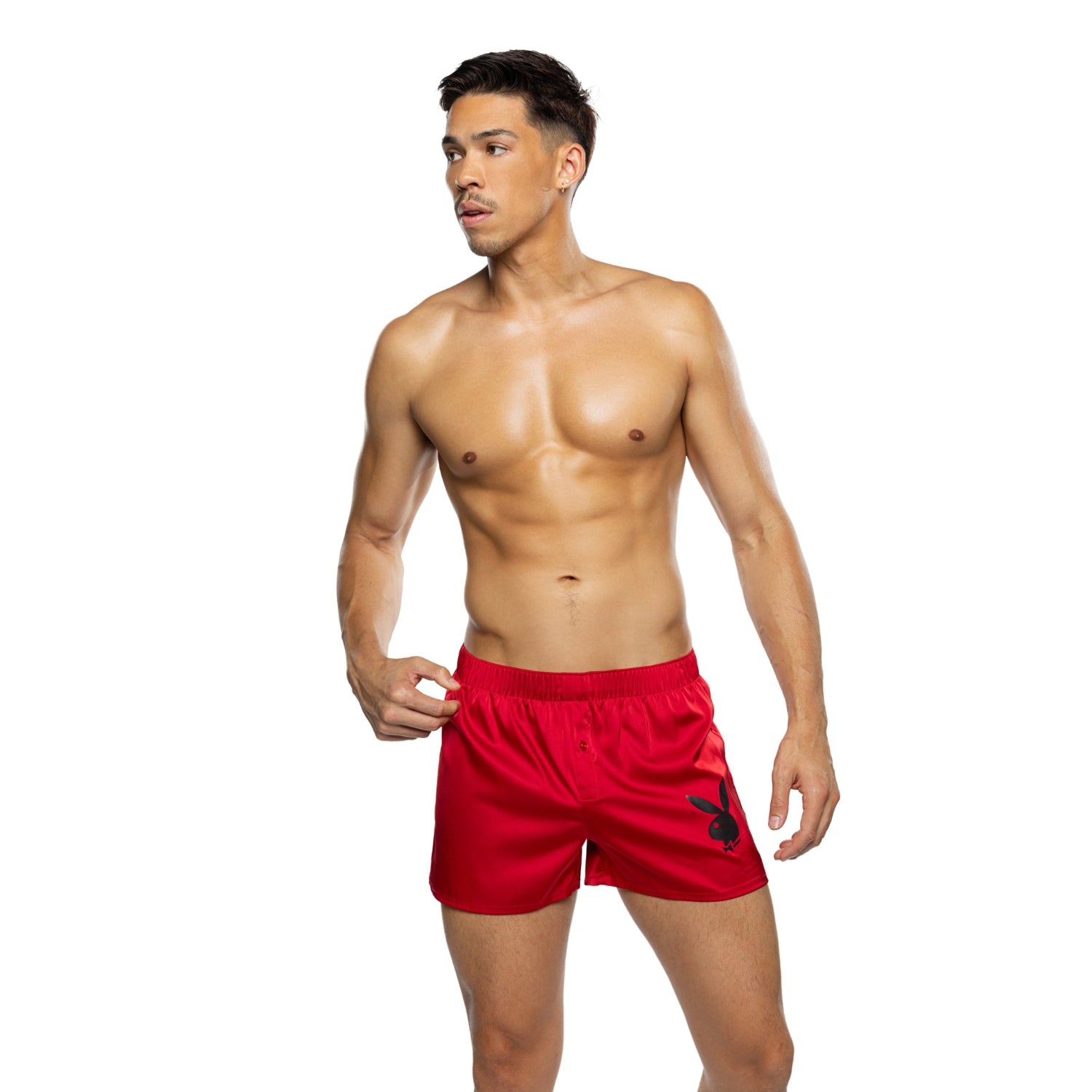 Shirtless man modeling red men's swim shorts with bunny logo on white background