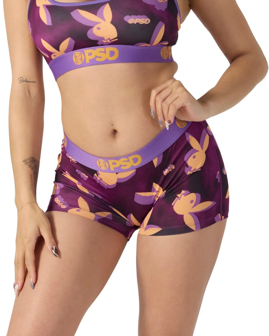 Purple and orange patterned sports bra and shorts set with 'PSD' branding on a white background.