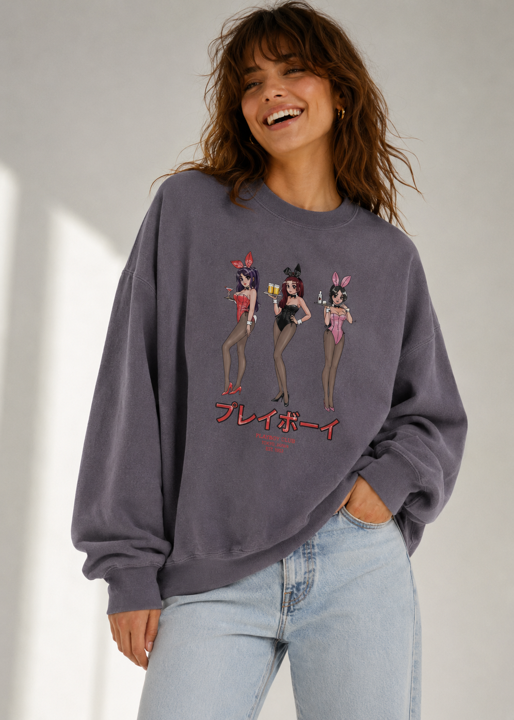 A woman wearing a washed dark gray crewneck sweatshirt with a graphic of three anime-style bunny girls and Japanese text, paired with light-wash blue jeans, set against a neutral studio background. #Women