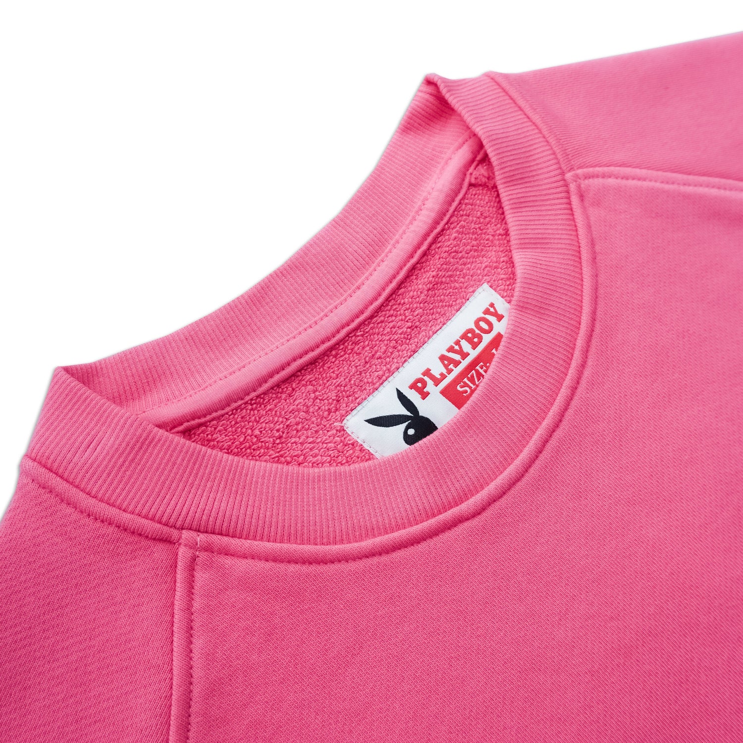 Close-up of a hot pink crewneck sweatshirt with ribbed collar and visible tag.