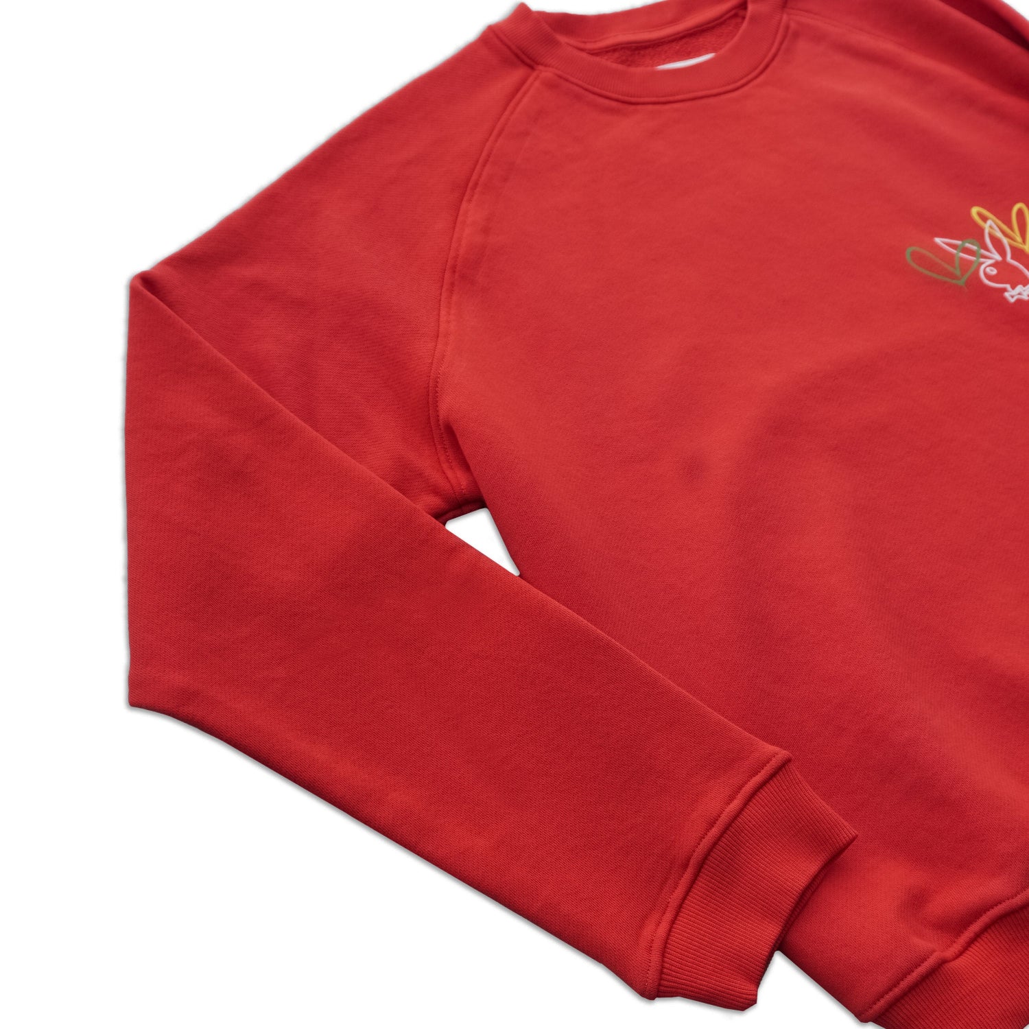Red crewneck sweatshirt with colorful embroidered bunny graphic on chest