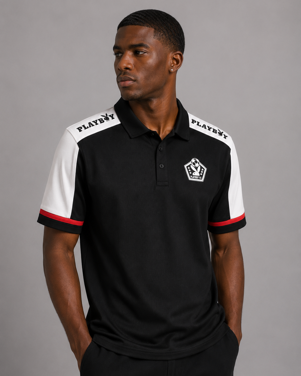 A man wearing a black and white short-sleeve polo shirt with red trim, featuring the Playboy logo on the shoulders and chest, against a solid gray studio background.