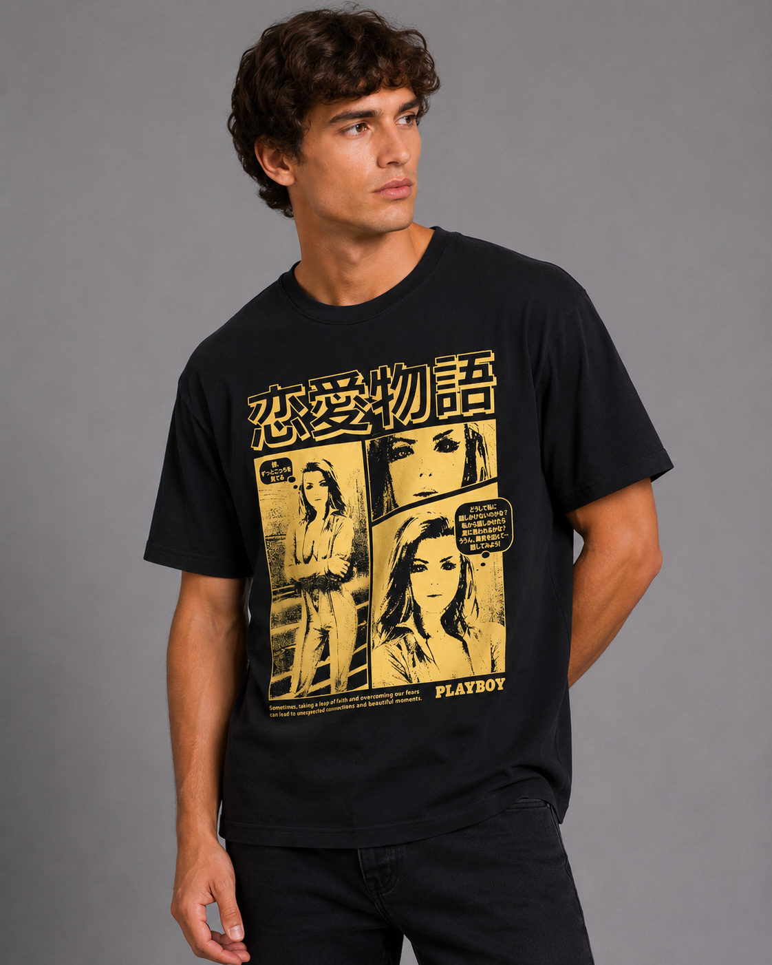 A man wearing a black short-sleeve graphic t-shirt with a yellow Japanese manga-style print featuring the Playboy logo and Japanese text, set against a plain gray studio background.