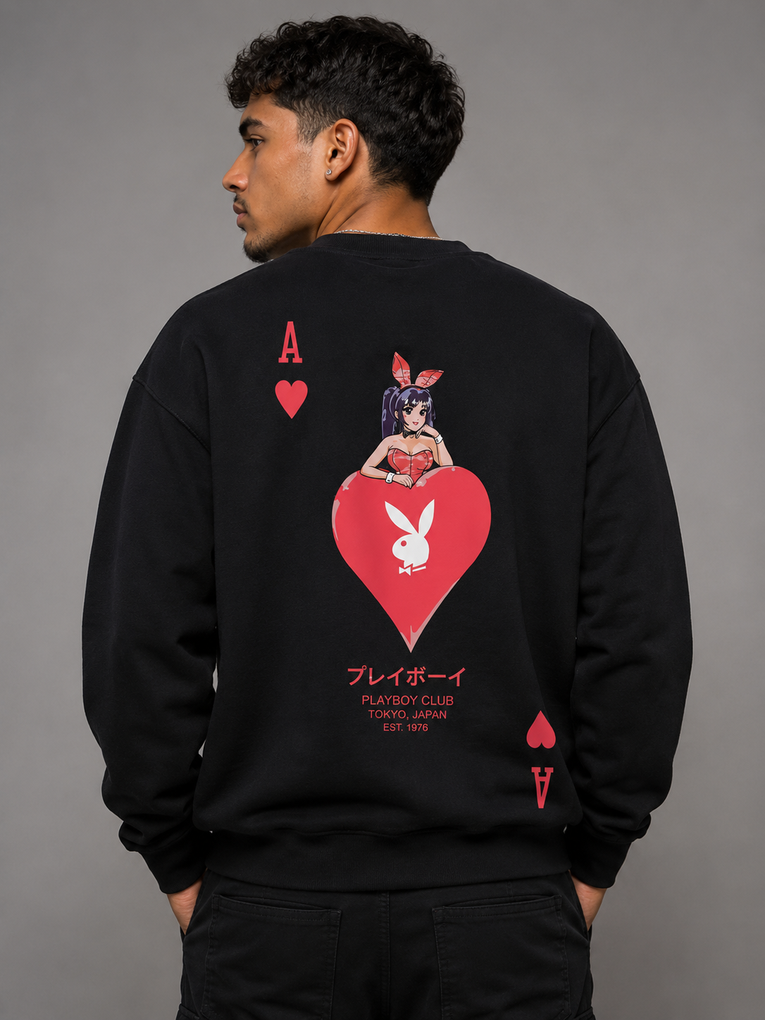 A man wearing a black sweatshirt, viewed from the back, featuring a large red and white graphic of an anime bunny girl on a heart with Playboy branding.