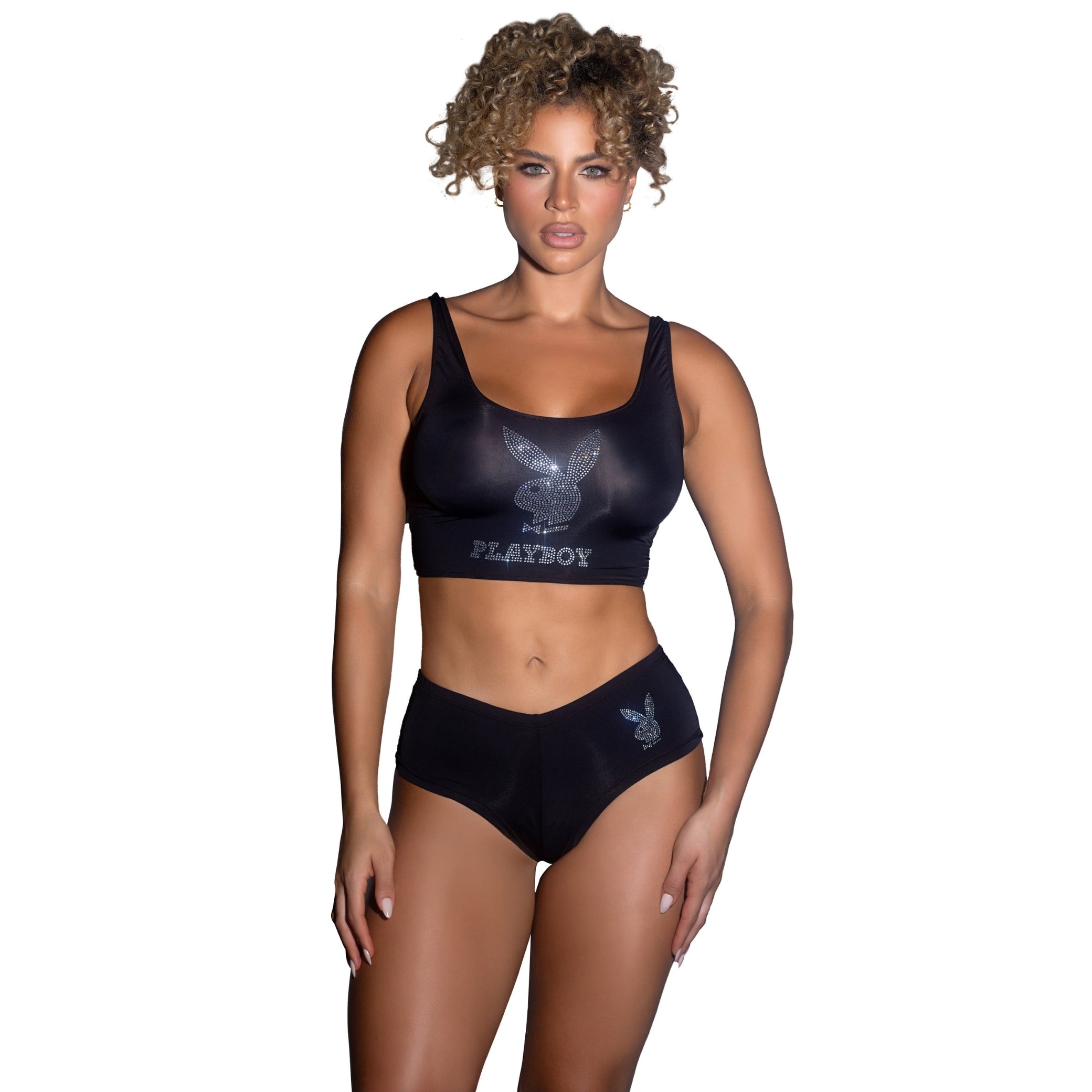Woman wearing a black Playboy sports bra and underwear set on a white background